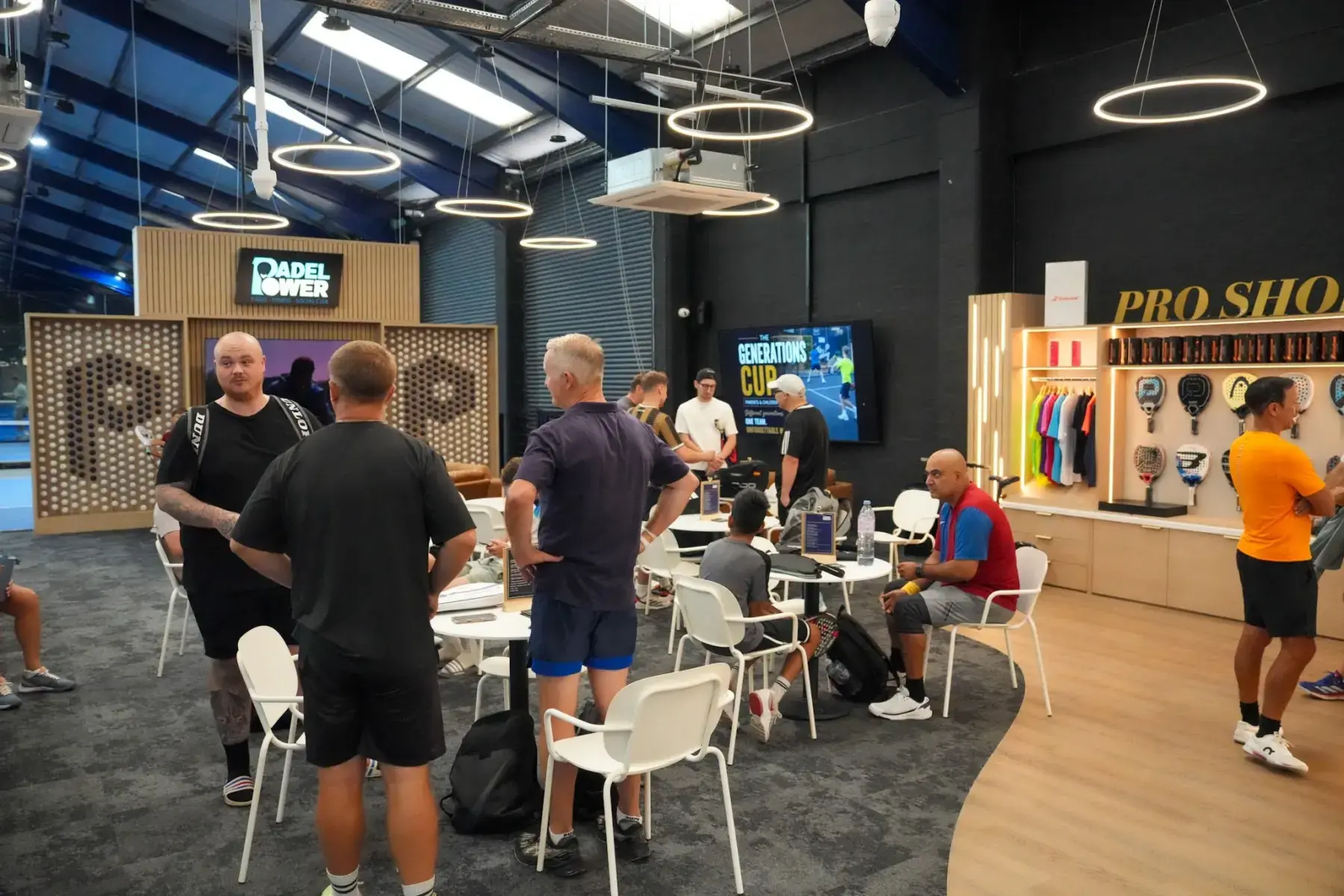Players gathered by the pro shop between matches on a tournament day at Padel Power
