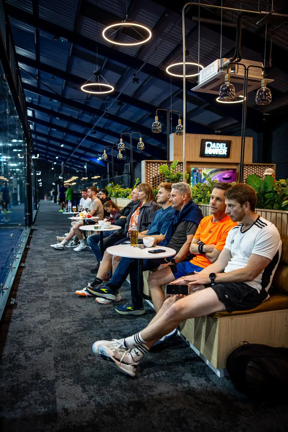 Players relaxing in the courtside lounge at Padel Power with drinks between games