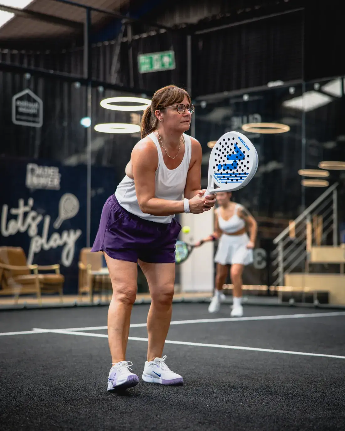 A player ready at the net in front of the let's play wall