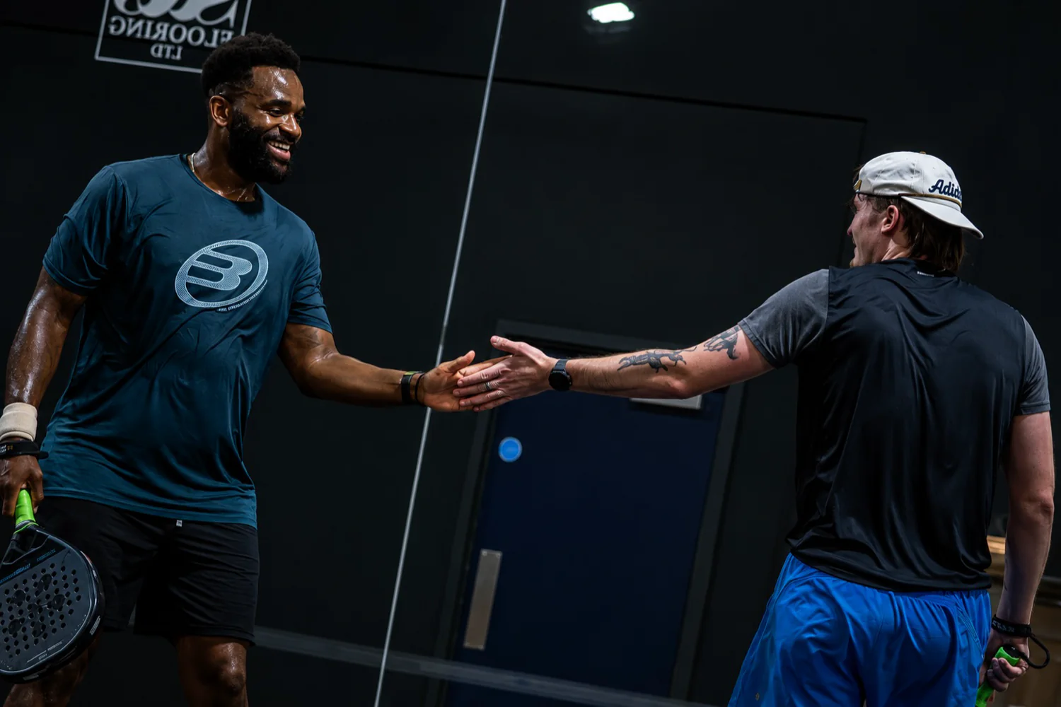 Two players celebrating a point on the indoor blue courts