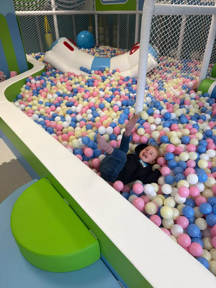 A child laughing in the Kids Zone ball pit