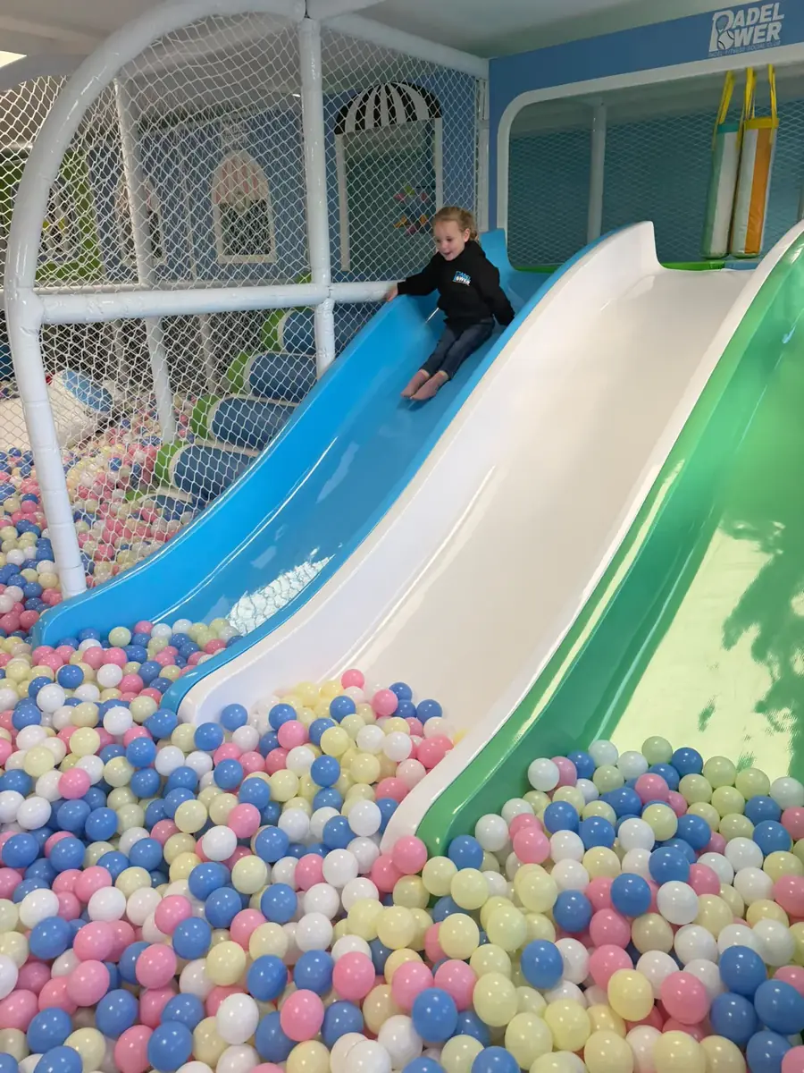 A child coming down the slide into the ball pit