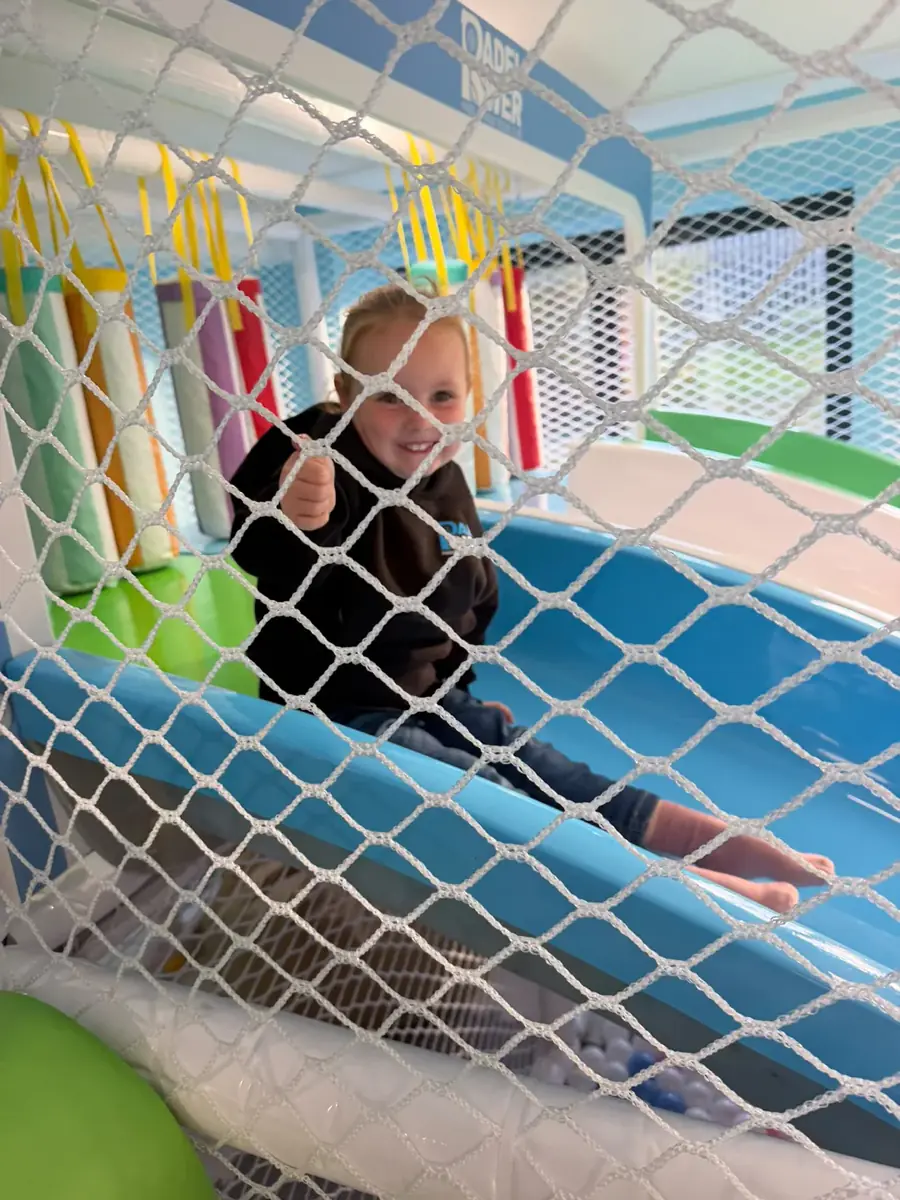 A child climbing the netted frame in the Kids Zone